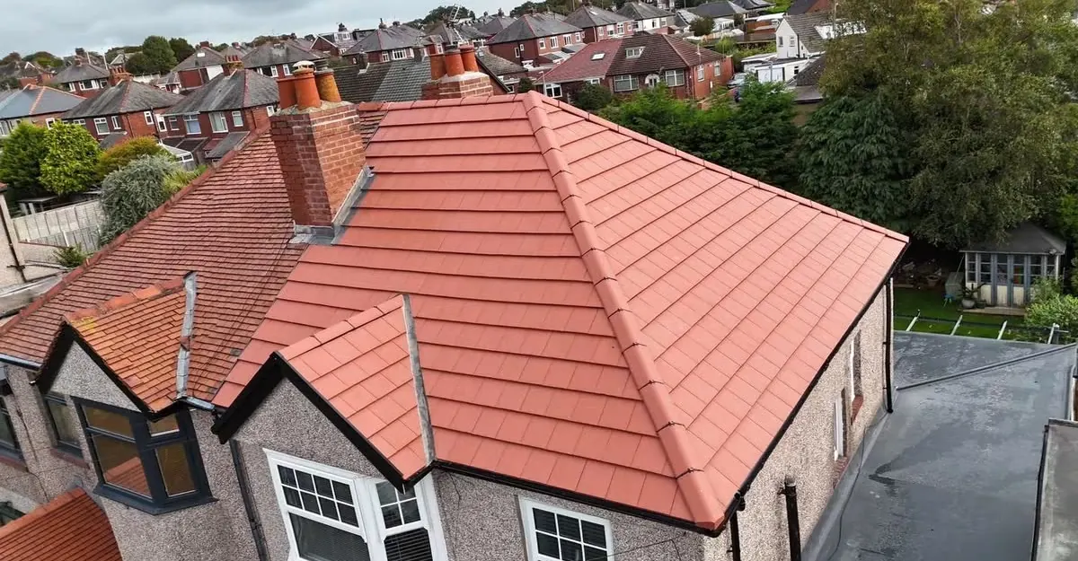 Red concrete tiled hipped roof finished by All Fix Roofing, seen from the scaffold